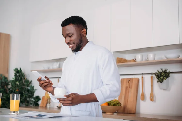 Hombre Afroamericano Con Taza Café Escribiendo Teléfono Inteligente Cocina — Foto de Stock