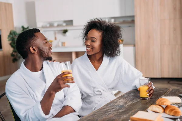 African American Couple Holding Glasses Juice Sitting Table Toasts Croissants — Stock Photo, Image