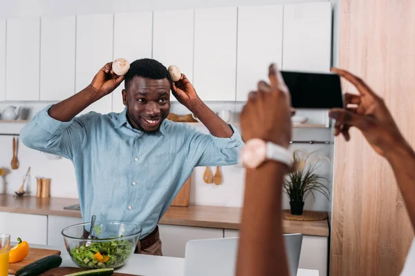 Cropped Image Woman Taking Photo Boyfriend Holding Mushrooms Head — Stock Photo, Image