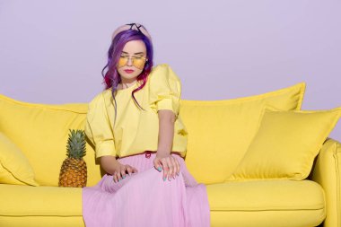 ananas ile sarı koltukta oturan moda genç kadın