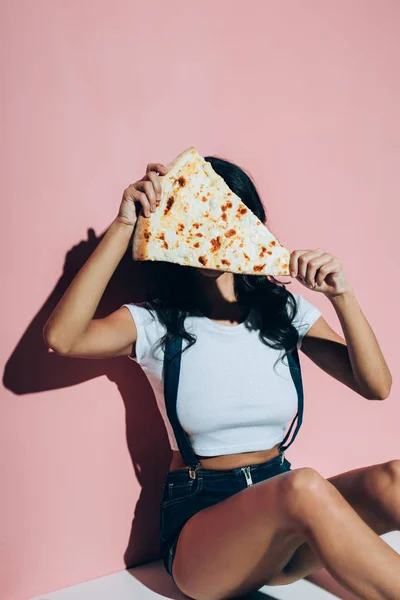 Tilsløret Visning Kvinde Dækker Ansigt Med Stykke Pizza Lyserød Baggrund - Stock-foto