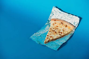 parça İtalyan pizza görünümü üzerinde mavi arka plan folyoyu kadar kapatın