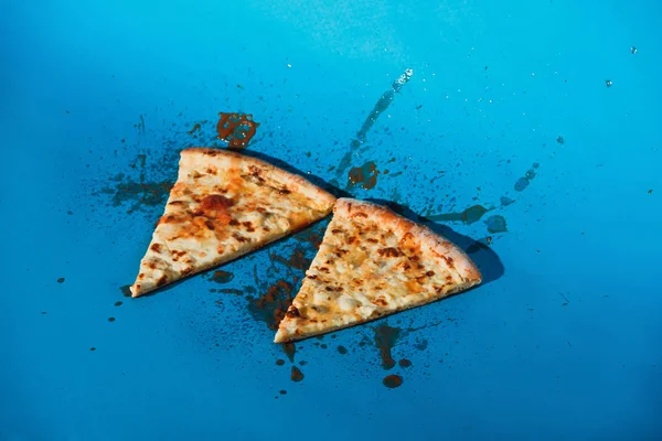 Close Van Stukken Van Gekookte Pizza Blauwe Achtergrond — Gratis stockfoto