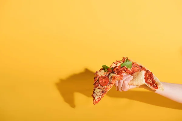 Частичный Вид Женщины Сжимающей Кусок Пиццы Руке Желтом Фоне — стоковое фото