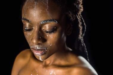 güzel şehvetli genç Afro-Amerikan kadın yüzündeki siyah izole dökülmüş süt ile