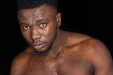 terli gömleksiz genç Afro-Amerikan adam siyah izole kamera bakıyor 