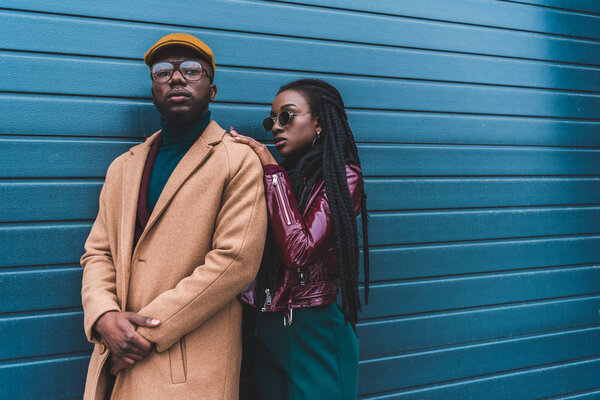 beautiful african american couple in fashionable outfit posing together outside  