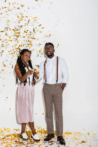 Стильна Молода Афроамериканська Пара Посміхається Камеру Стоячи Білому Золотим Конфетті — стокове фото