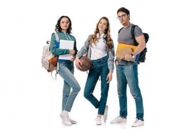 çok kültürlü öğrenciler kitap ve üzerinde beyaz izole basketbol topu ile kameraya bakıyor