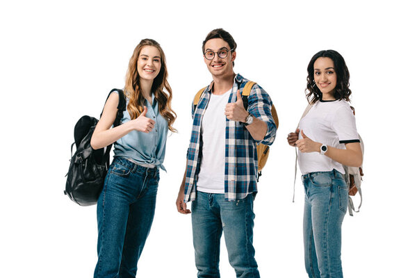 smiling multicultural students showing thumbs up isolated on white