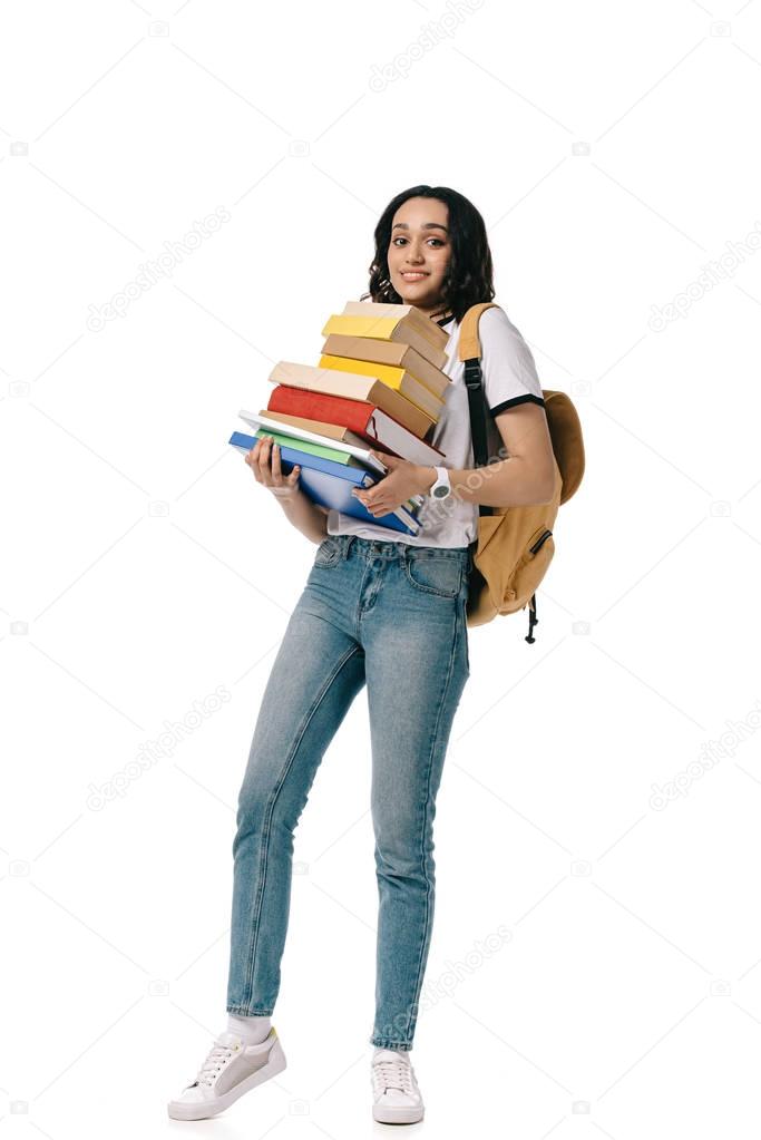african american teen student holding heavy stack of books isolated on white