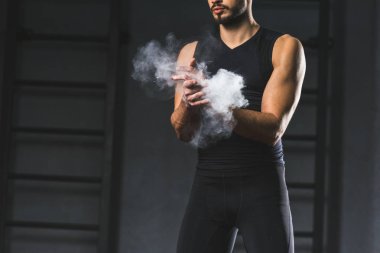 Genç sporcu spor salonunda elinde tebeşir tozu yayılan kırpılmış görüntü