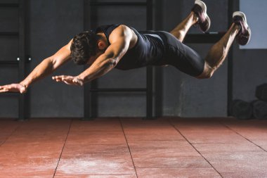 Genç sporcu spor salonunda push up için atlama görünümünü