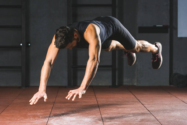 Young sportsman doing push ups  in sports hall