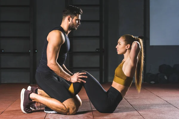 Treinador Masculino Ajudando Jovem Esportista Fazer Abdominais Sala Esportes — Fotografia de Stock