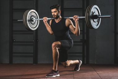 Genç sporcunun egzersiz halter salonunda omuzlarında ile yapmak