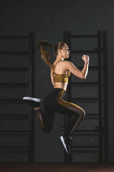 跳运动员在健身房做有氧运动的侧面观 — 图库照片
