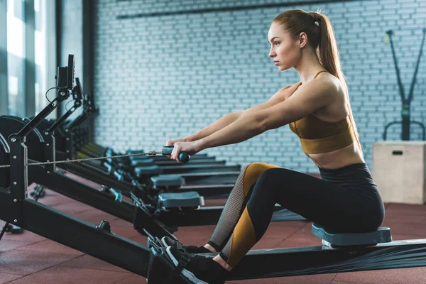 Zijaanzicht Van Sportvrouw Doen Oefening Roeiapparaat Sportcentrum — Stockfoto