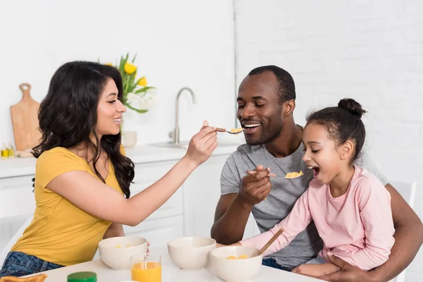快乐的年轻家庭互相喂养与早餐在厨房一起 — 图库照片