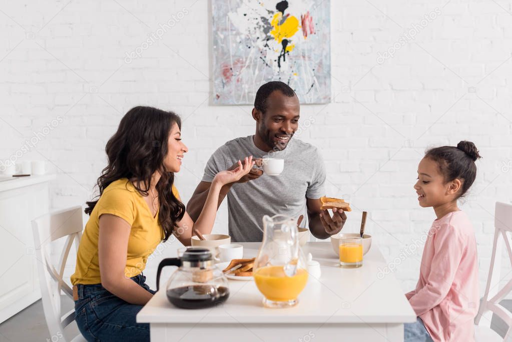 beautiful young family having breakfast on kitchen together