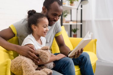 mutlu genç Baba ve kızı evde birlikte kitap okuma