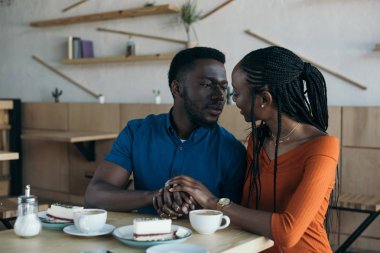 kafede romantik tarihte portre Afrikalı-Amerikalı çiftin birbirine bakarak ve tutan eller