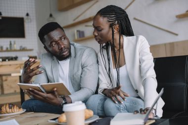 Cafe iş toplantısı sırasında tartışırken Afro-Amerikan iş adamları iş