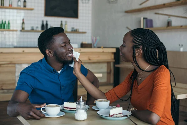 Försiktig Afroamerikanska Kvinna Rengöring Pojkvänner Ansikte Med Servett Bordet Café — Stockfoto