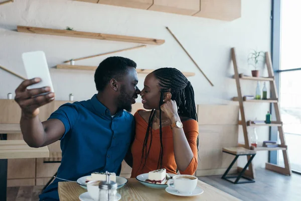 stock image selective focus of african american couple taking selfie on smartphone together in coffee shop