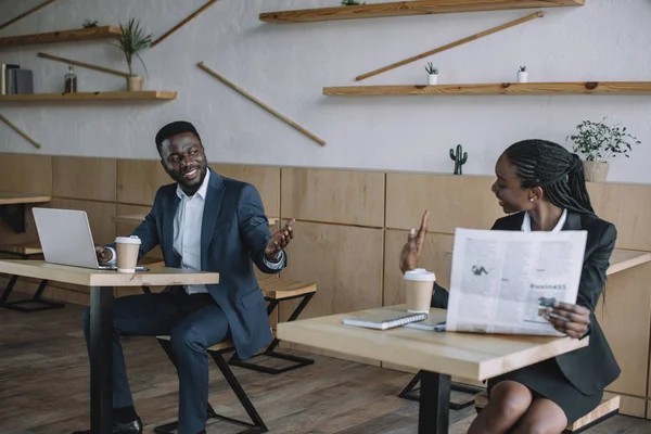 African American Businessman Working Laptop While Colleague Reading Newspaper Cafe — Stock Photo, Image