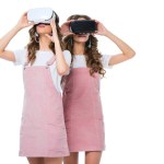 Mladá dvojčata sledovat něco ve virtuální realitě sluchátka izolované na bílém