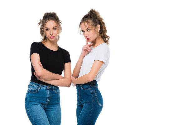 confident attractive young twins looking at camera isolated on white