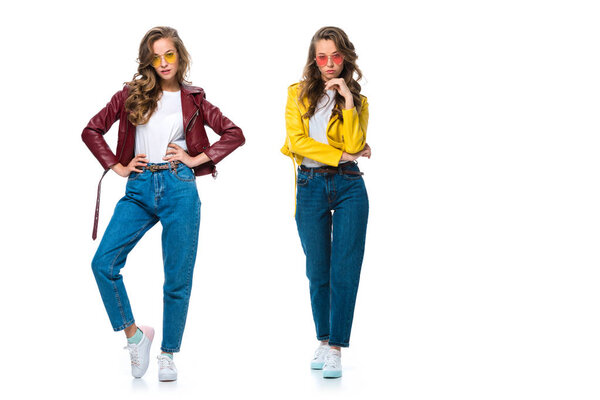 attractive fashionable twins posing in leather jackets and sunglasses isolated on white