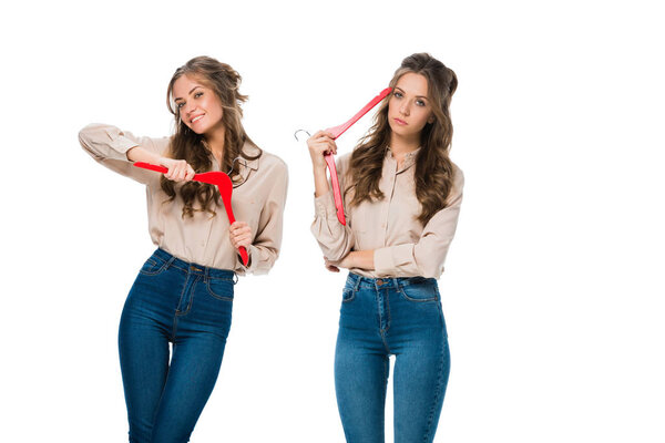 счастливые и скучные близнецы с вешалками, смотрящие на камеру, изолированную на белом, торговый концепт
