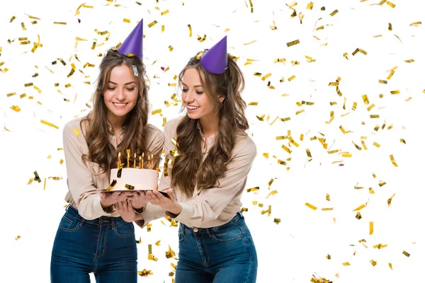 Smiling Twins Birthday Caps Looking Birthday Cake Falling Confetti Isolated — Stock Photo, Image