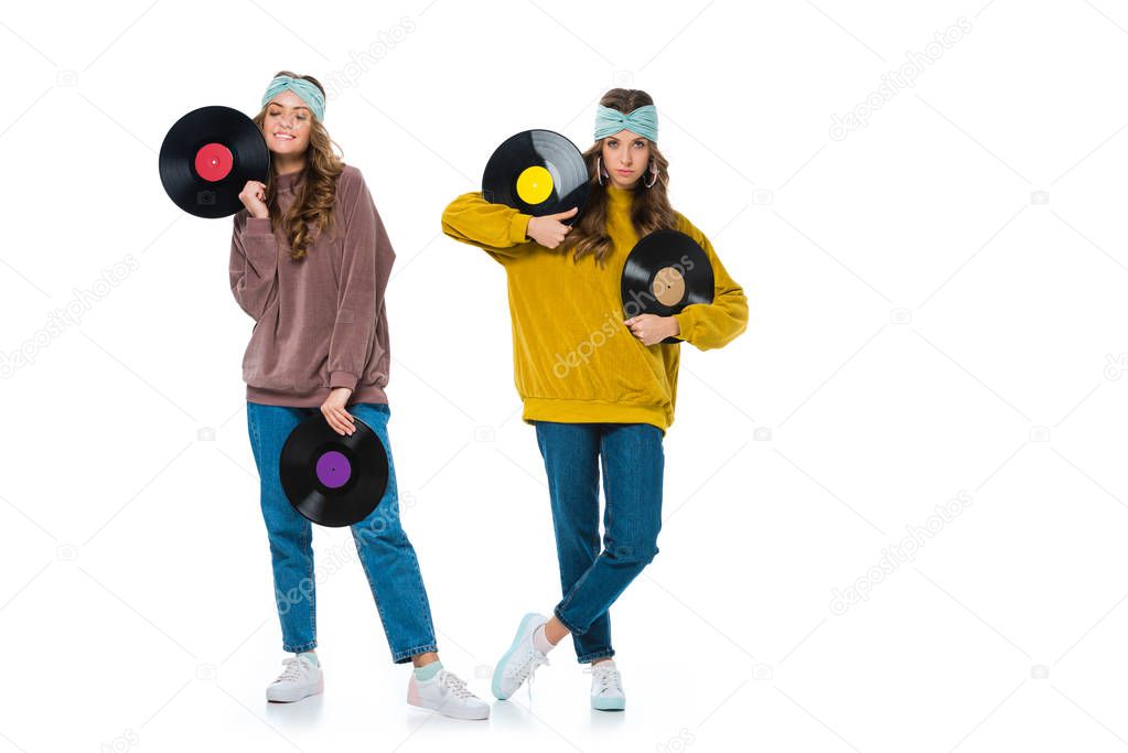 attractive retro styled young twins with phonograph records isolated on white