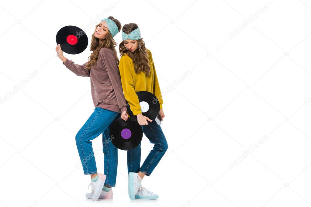 attractive retro styled young twins with LP vinyls isolated on white