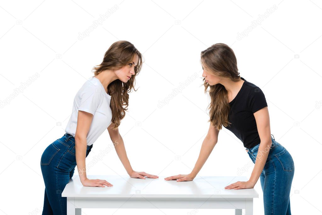 side view of angry twins looking at each other isolated on white