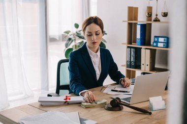 Tokmak, Doları banknot, rüşvet ve office içinde laptop ile işyerinde kadın avukat