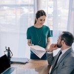 Lawyer and client with contract having discussing at workplace with laptop in office