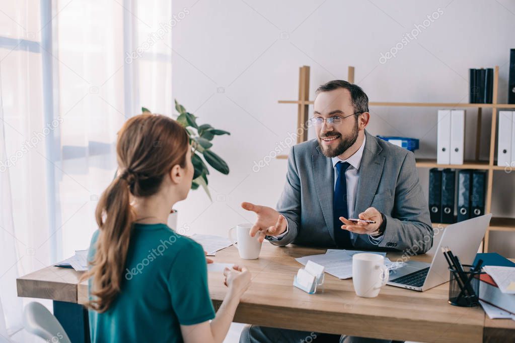 businessman and client discussing contract during meeting in office