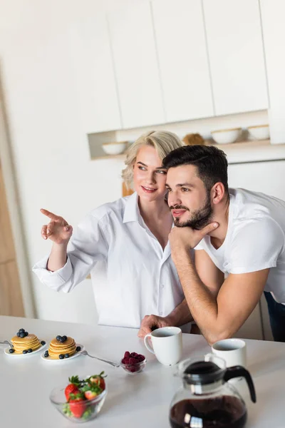 Lächelndes Junges Paar Schaut Beim Gemeinsamen Frühstück Weg — Stockfoto