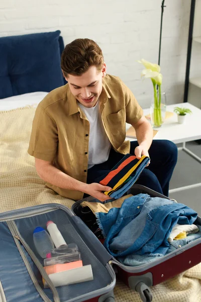 Handsome Smiling Man Packing Clothes Vacation — Stock Photo, Image