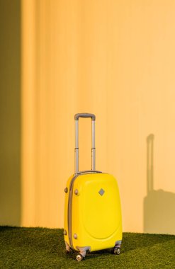 yellow travel bag on floor at home clipart
