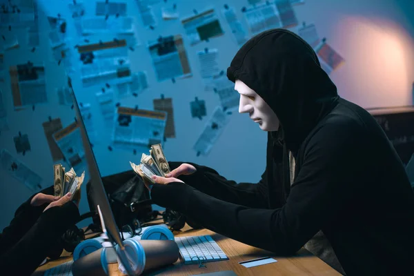 Widok Boku Kapturem Hacker Masce Liczenia Skradzione Pieniądze Jego Miejscu — Zdjęcie stockowe