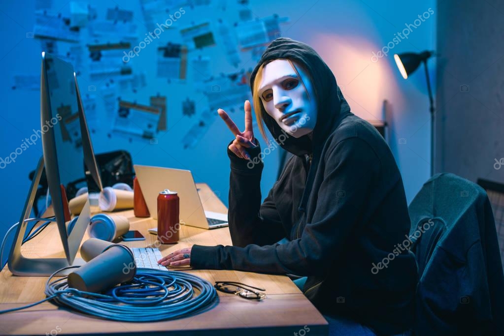 Download Female Hacker Mask Showing Sign Workplace — Stock Photo © VitalikRadko #190886588