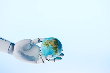 robot hand holding earth model isolated on blue, earth day concept