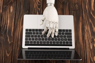 laptop ile ahşap yüzeyde çalışan robot resmini kırpılmış