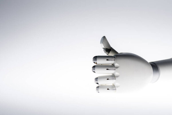рука робота показывает большой палец вверх, изолированный на сером

