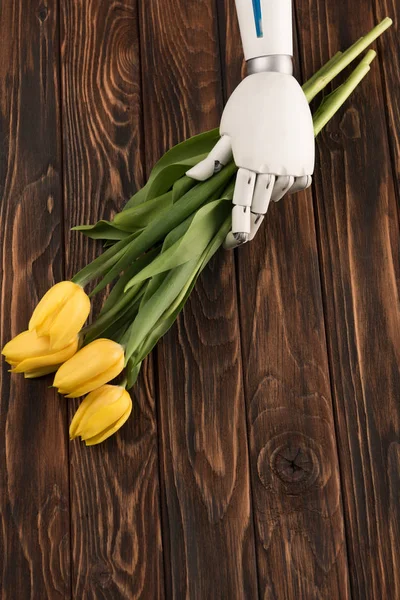 Cropped Shot Robot Holding Bouquet Yellow Tulips Wooden Surface — Free Stock Photo